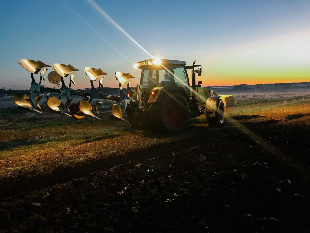 a tractor on a field in the dark